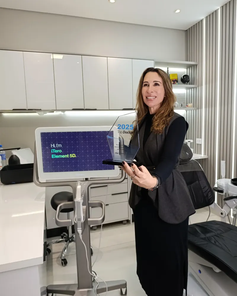 Dra. Carmen Calixto na clínica ao lado do iTero Element 5D, segurando o troféu Align Technology Top Doctor 2025.